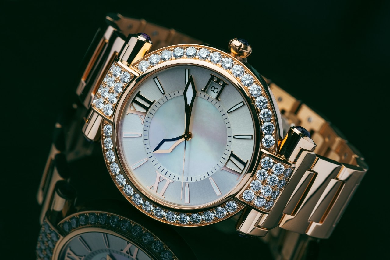 a yellow gold watch with diamond accents on both the bezel and the case
