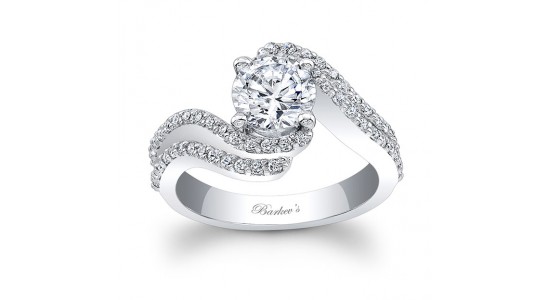 a white gold engagement ring by Barkev featuring a curved band and round cut center stone