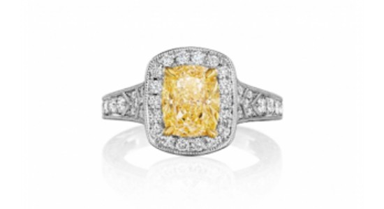 a white gold halo ring by Henri Daussi featuring a yellow center stone