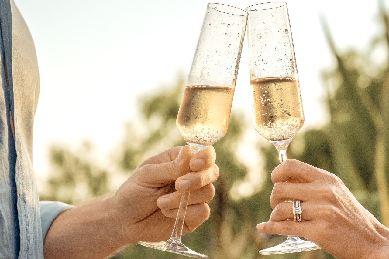 Two celebrate with champagne after a holiday proposal with the Tacori engagement ring in view