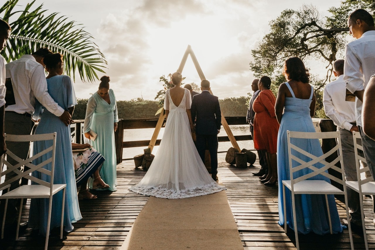 a bride and groom standing at an altar overlooking a body of water
