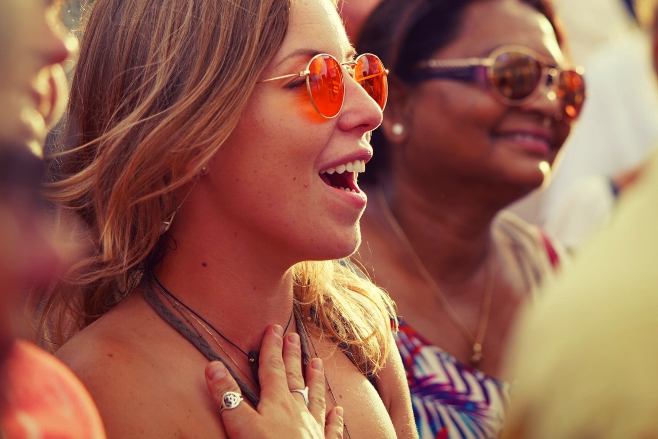 Fashionable woman smiles at a summertime music festival.