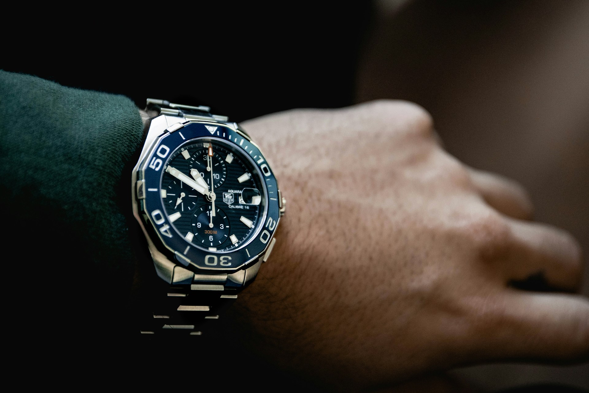 a man’s wrist wearing a TAG Heuer Aquaracer watch