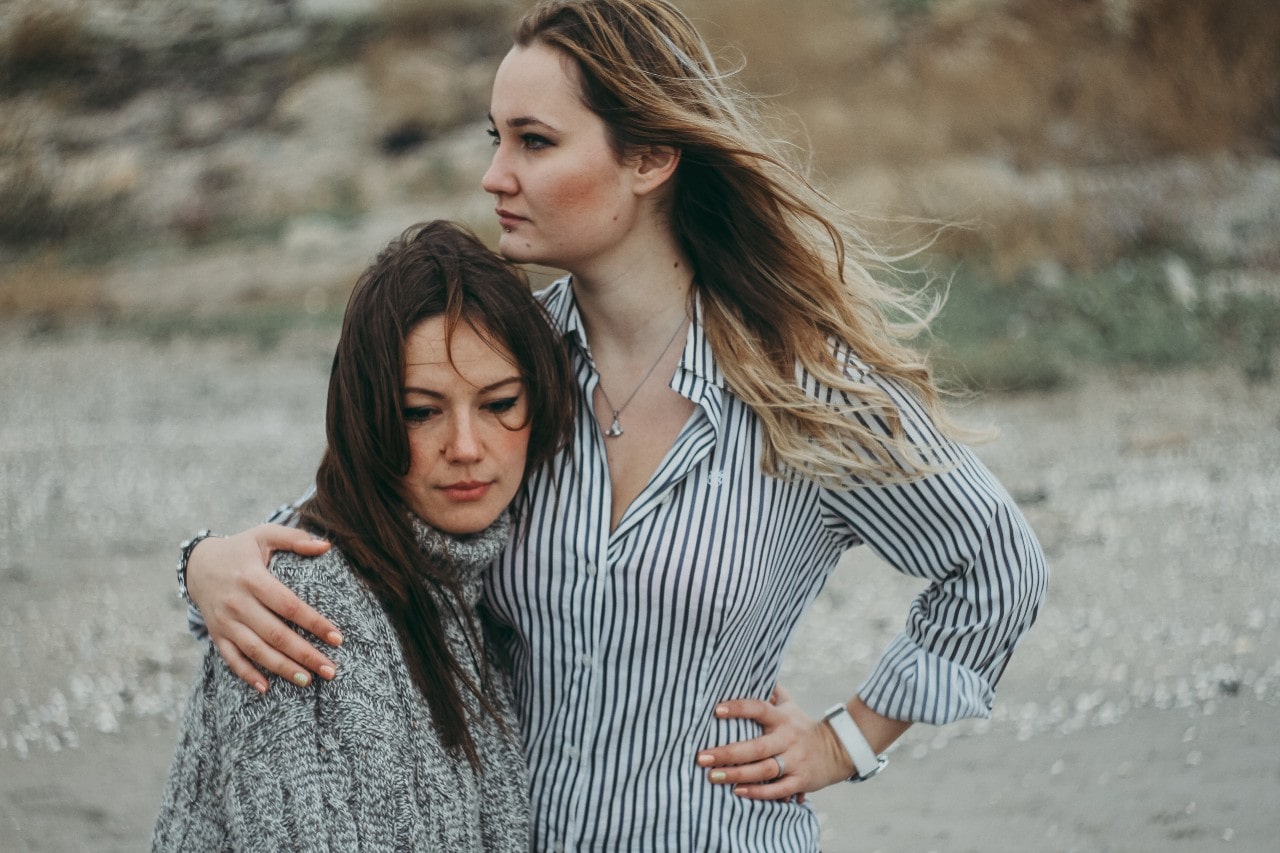 two ladies standing on a beach and wearing watches